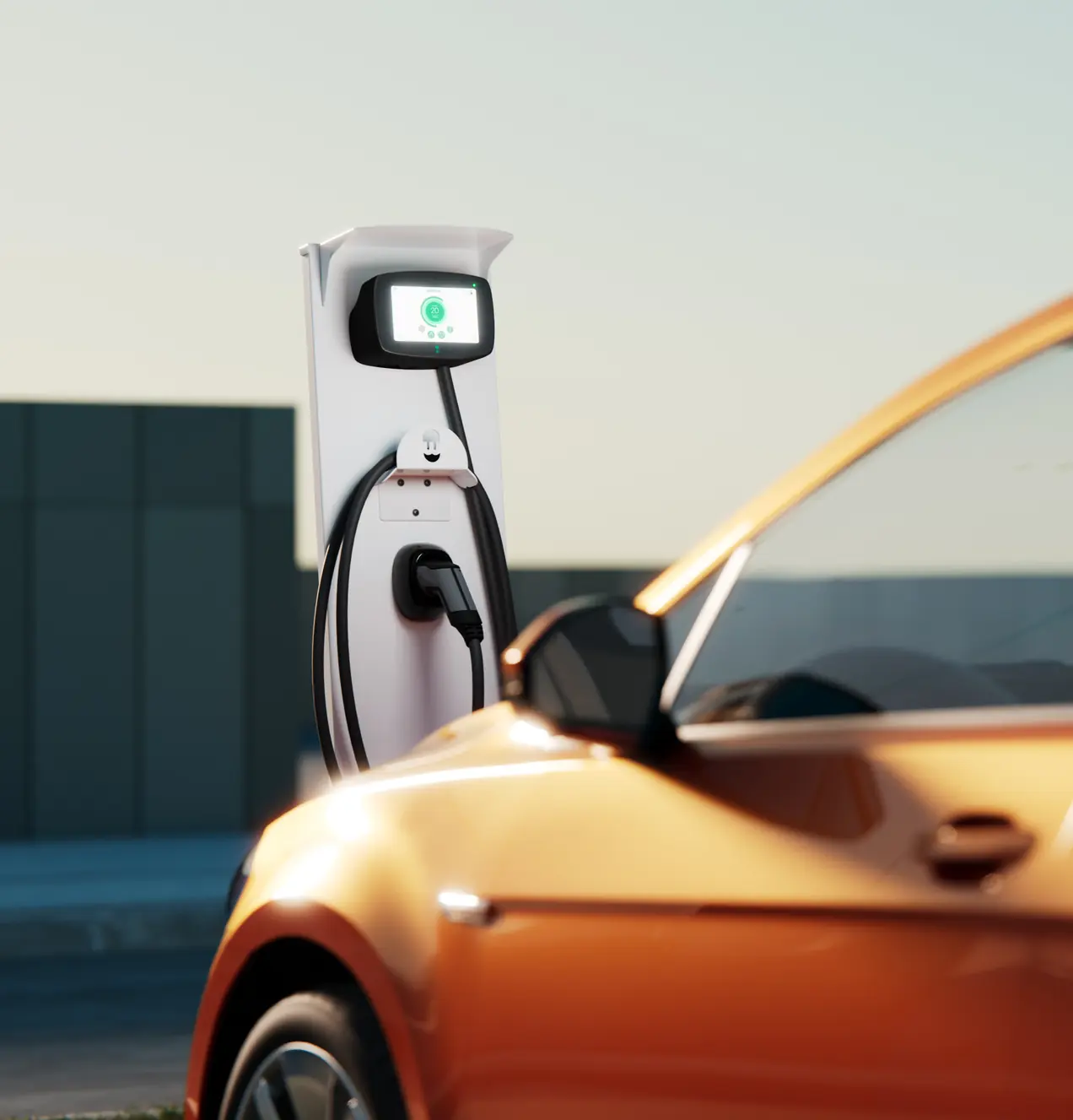 Fehér fali töltőoszlop, előtte töltés alatt álló narancssárga elektromos autó