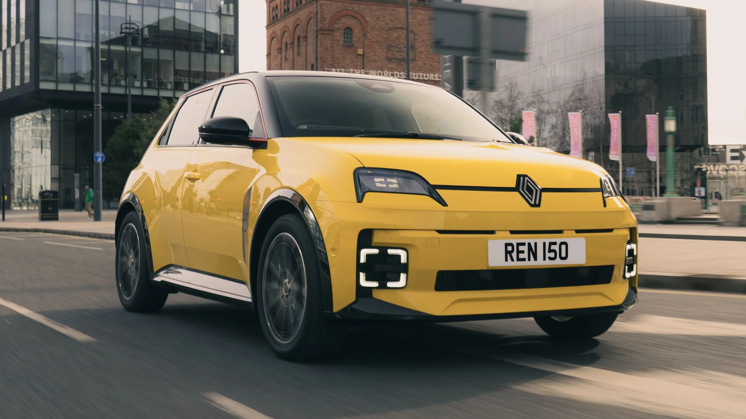 Sárga elektromos kisautó közlekedés közben, sportos megjelenésű elektromos autó kis méretben, erős motor és hatékony akkumulátor, rövid és hosszú utakra is alkalmas.